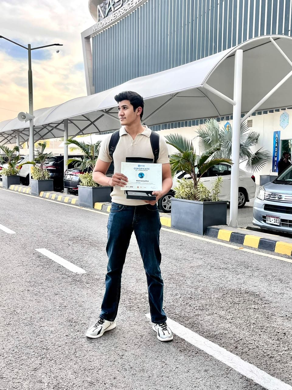 Hashir holding a team certificate outside the National Aerospace Science and Technology Park