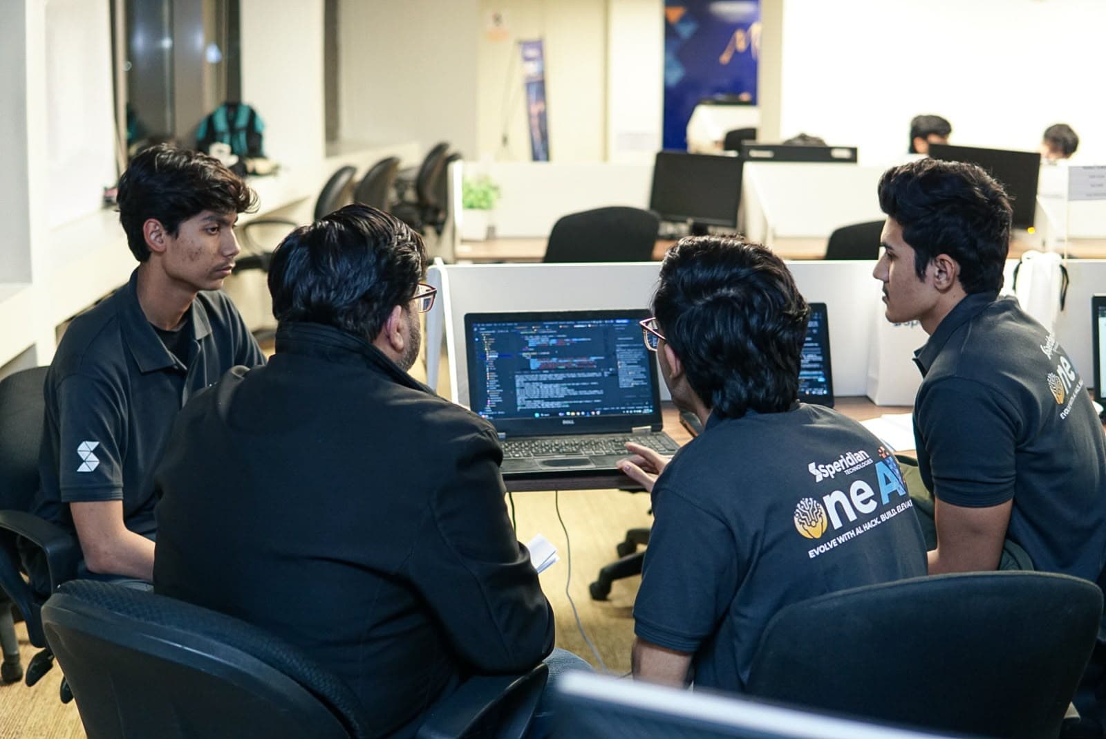 Hashir and his team reviewing code together on a laptop